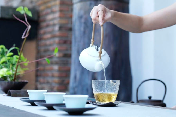 Person pouring tea from a pot