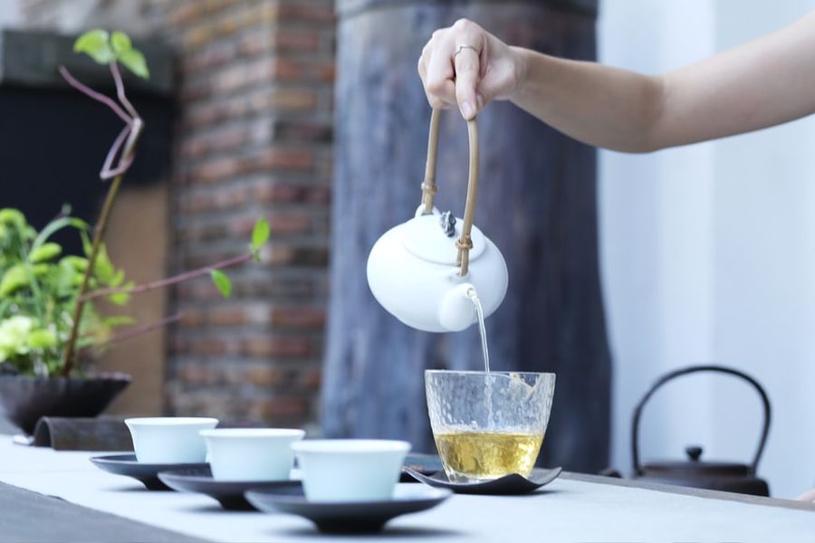 Person pouring tea from a pot