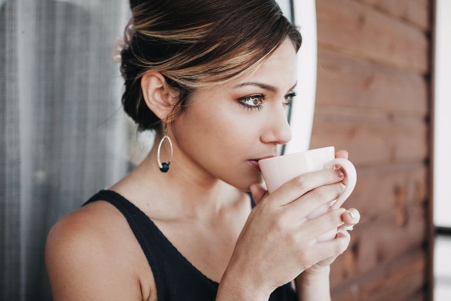 Woman tasting a cup of CBD coffee