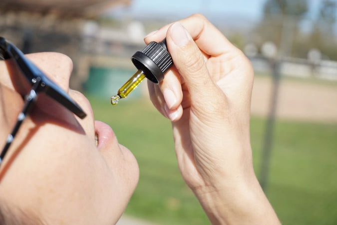 Woman taking a CBD oil directly in her mouth